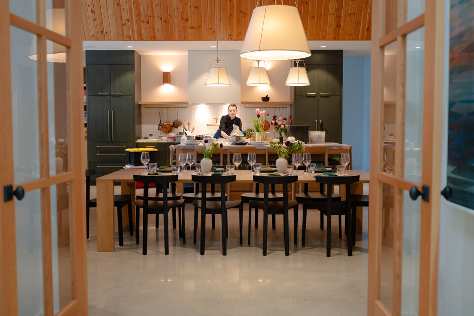 A private chef plating dinner beneath the pendant lights of the Main Cabin kitchen