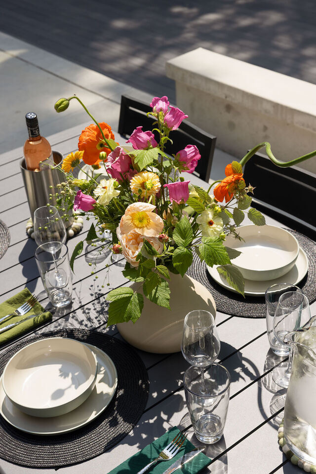 An outdoor tablescape with garden flowers on the deck