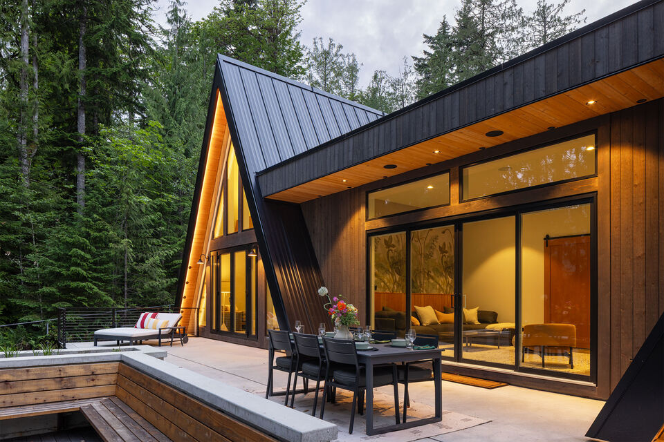 Dinner on the deck at dusk with the doors open to the lit cabin interior