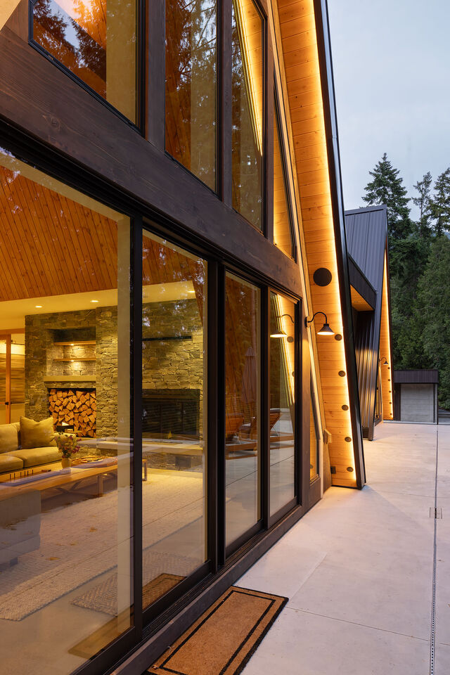 The A-frame glass wall glowing into the evening