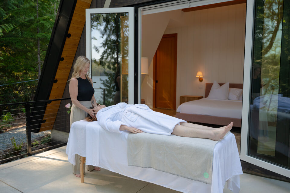 A massage treatment on the private deck beside the A-frame, the bedroom open behind