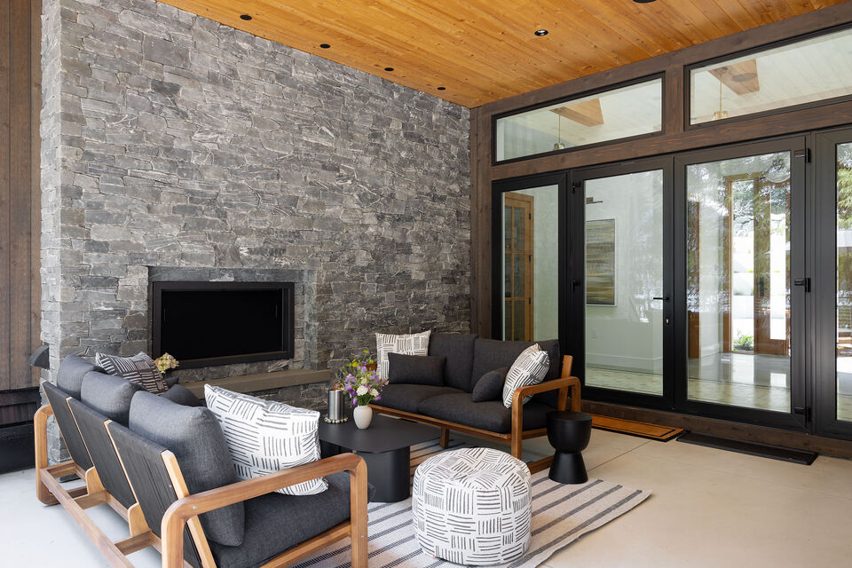 The covered terrace lounge with its stone fireplace, open to the interior
