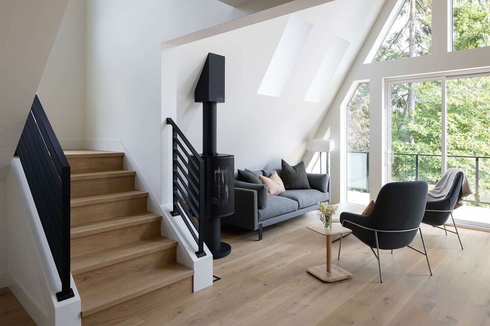 Cabin 1 staircase and wood stove with lounge chairs by the window