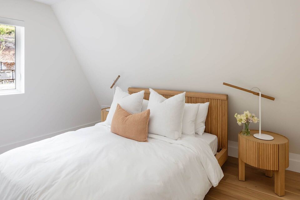 Cabin 1 bedroom with wood headboard and peach accent pillows