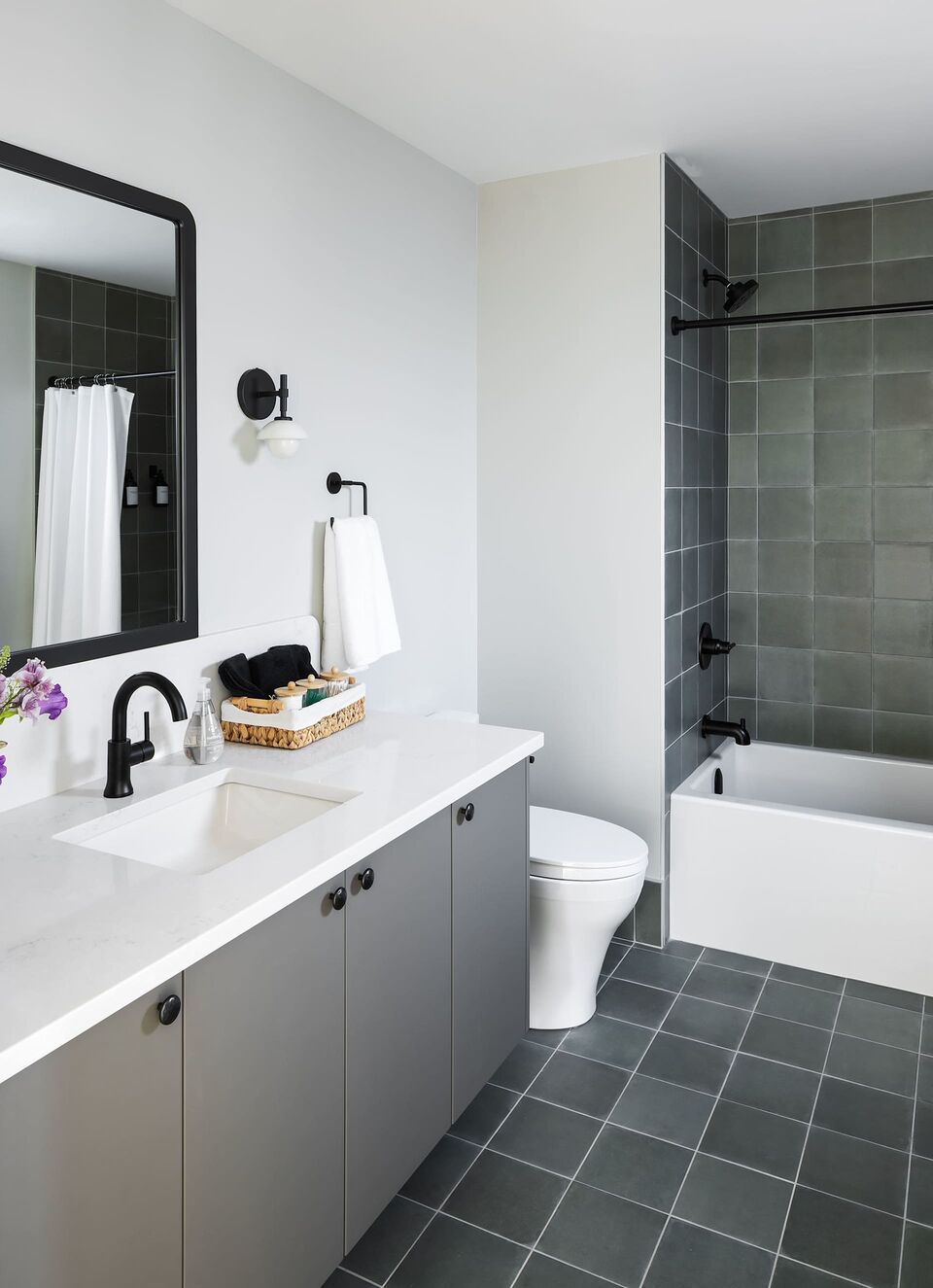 Cabin 2 bathroom with grey vanity and green tile tub surround