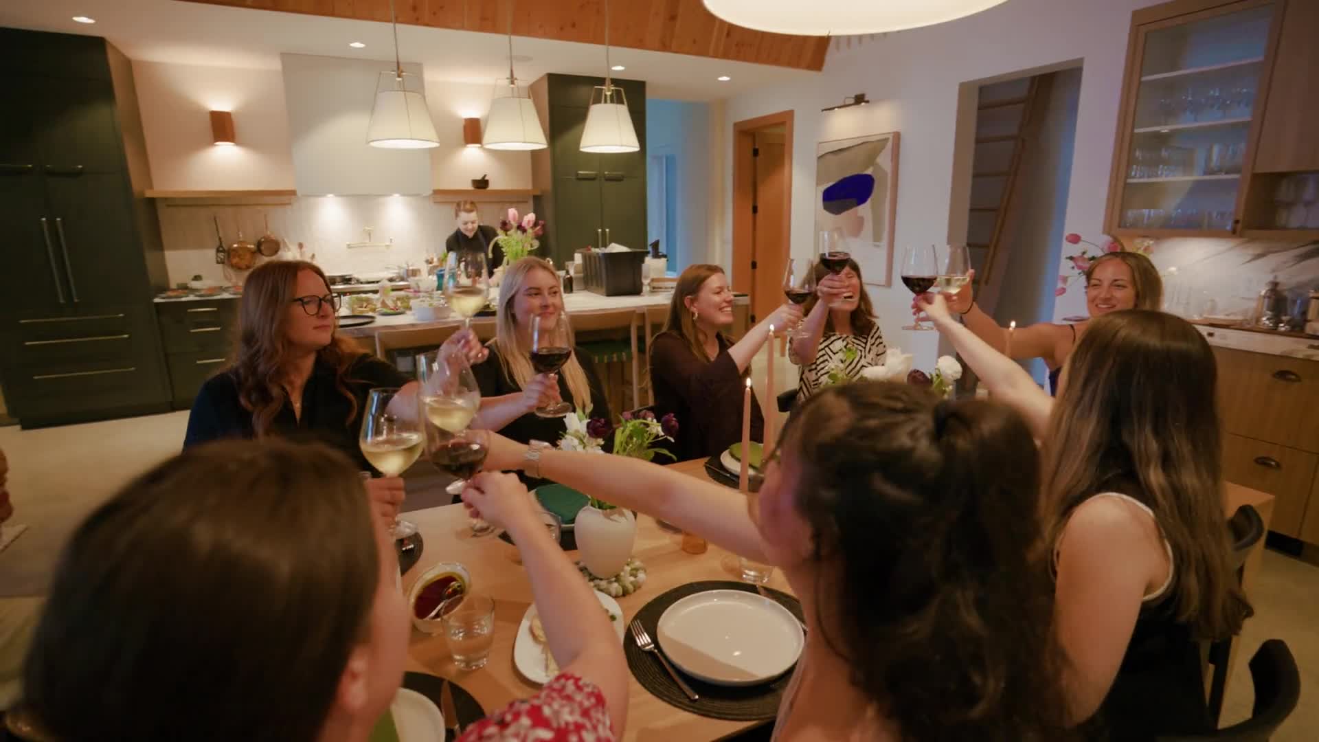 Guests raise their glasses in a toast around the long table